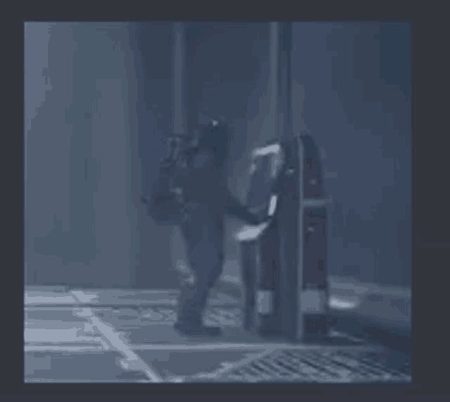 a person is standing in a dark room next to a gas pump .