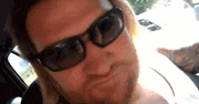 a man wearing sunglasses is sitting in a car .