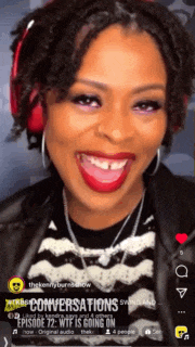 a woman wearing red headphones and a black and white striped shirt is smiling