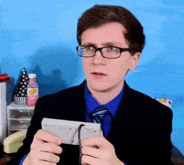 a man wearing glasses and a blue shirt is holding a white box