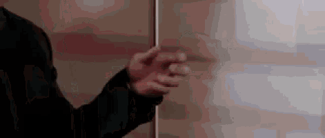a close up of a person 's hand pointing at something while standing in front of a white board .