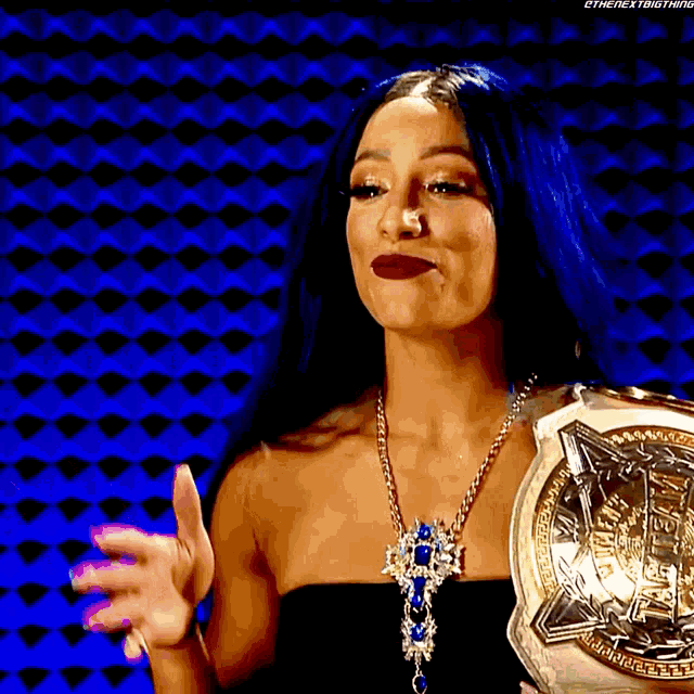 a woman in a black top is holding a championship belt