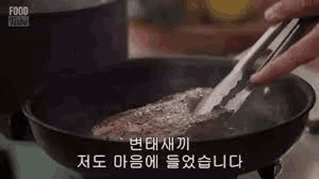 a person is cooking a steak in a skillet on a stove .