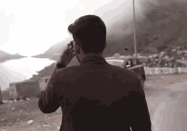 a man in a brown jacket is walking down a road