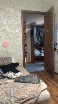 a bedroom with a pink heart on the wall behind the door