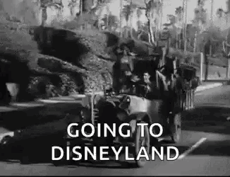 a black and white photo of a group of people riding in a car going to disneyland .