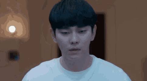 a close up of a man 's face with a white shirt on