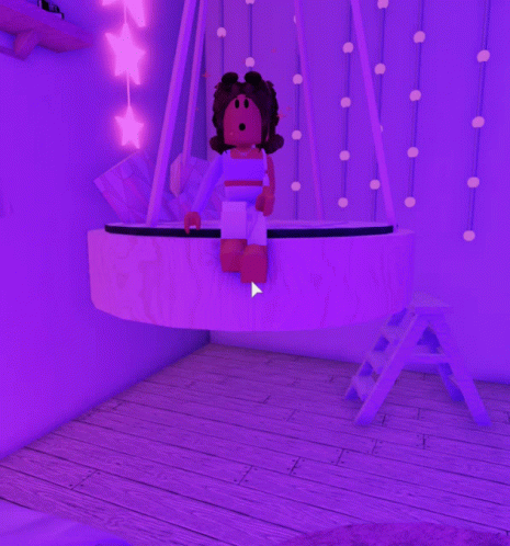 a girl is sitting on a purple swing in a room