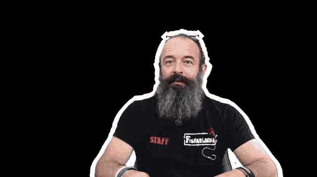 a man with a beard wearing a black shirt that says staff