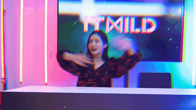 a woman is dancing in front of a tv screen that says it mild