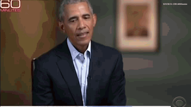 a man in a suit and tie is sitting in front of a screen that says 60 minutes on it