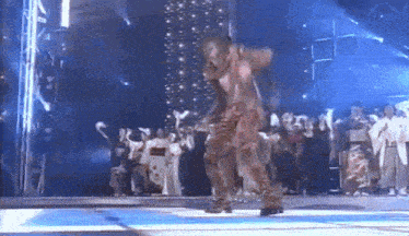 a man dancing on a stage in front of a crowd