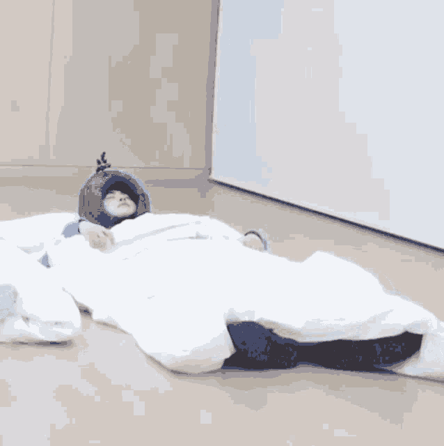 a person is sleeping in a sleeping bag on the floor