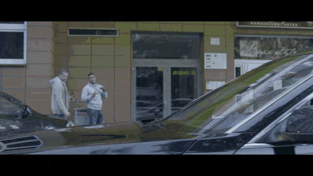 a man smoking a cigarette in front of a building with the number 13