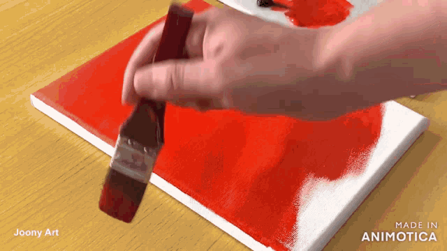 a person is holding a brush over a canvas that says made in animotica