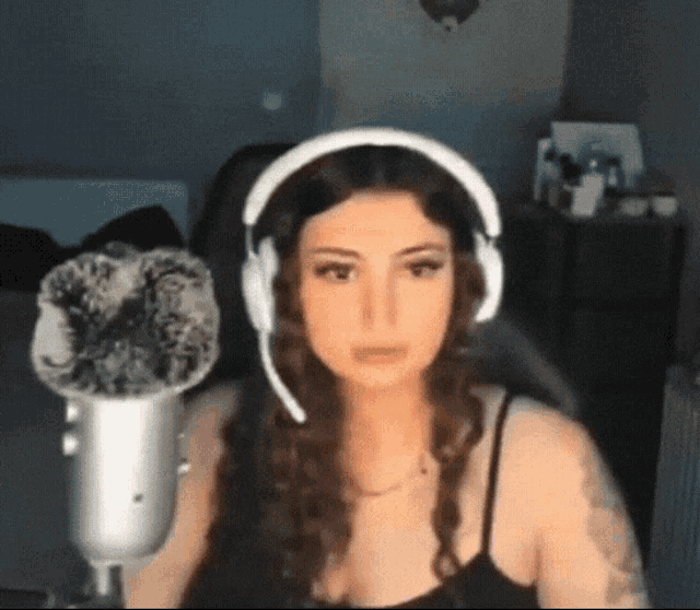 a woman wearing headphones and a microphone looks at the camera