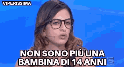 a woman wearing glasses is talking into a microphone and says non sono più una bambina di 14 anni .
