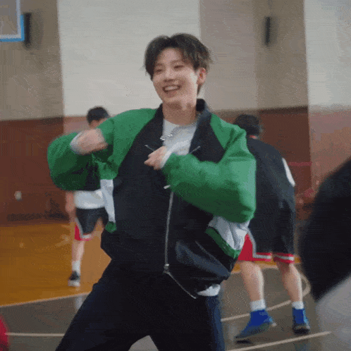 a man in a green jacket is dancing on a court