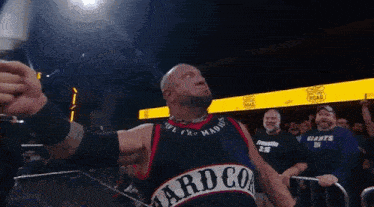 a man in a hard core jersey stands in front of a crowd of people