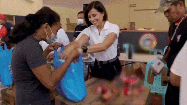 a woman is giving a bag of food to another woman
