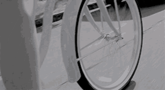 a black and white photo of a person riding a bike .