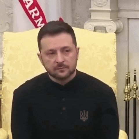 a man with a beard is sitting in a chair .