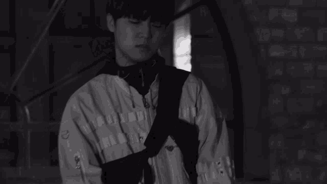 a black and white photo of a young man wearing headphones .