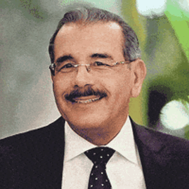 a man with a mustache wearing a suit and tie