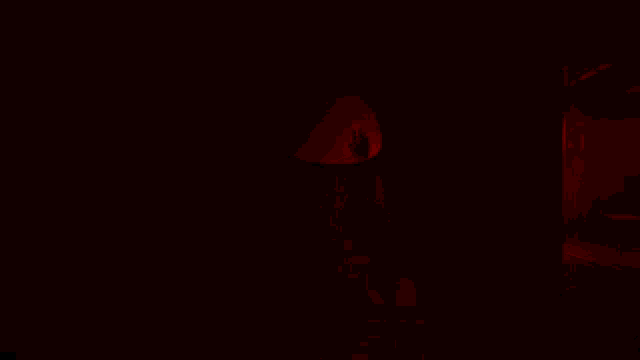 a person is standing in a dark room with a red exit sign on the wall