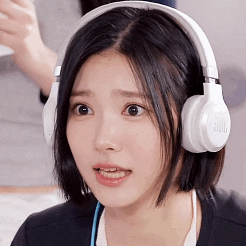 a woman wearing jbl headphones looks surprised