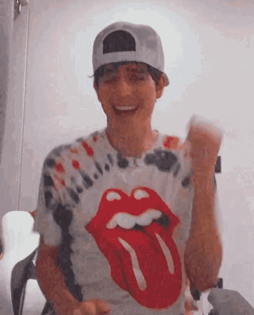 a young man wearing a tie dye rolling stones t-shirt