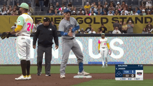 a baseball game is being played in front of a gold stand banner