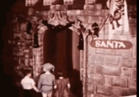 a group of people are standing in front of a brick building with a sign that says santa .