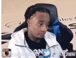 a man in a white jacket is sitting in a chair with a twitter logo on the bottom right