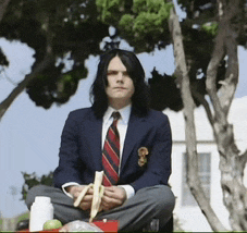 a man in a suit and tie is sitting in a lotus position holding a banana