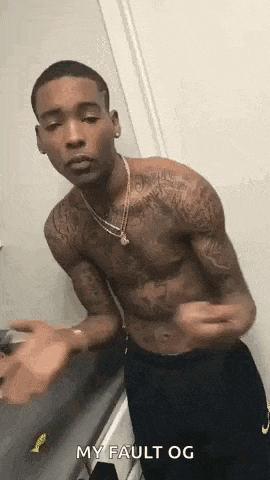 a shirtless man with tattoos on his arms and chest is standing in front of a mirror .