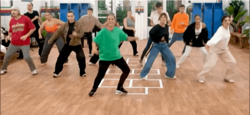 a group of people are dancing in a room and one of them is wearing a shirt that says ' warriors ' on it