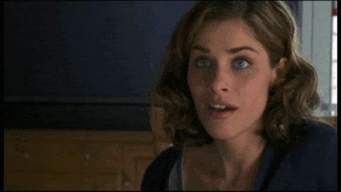 a close up of a woman 's face with a blue shirt on