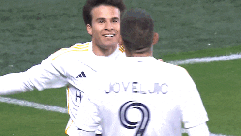two soccer players are hugging and one has the number 9 on his jersey