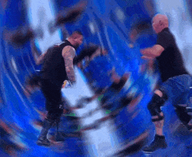 a blurry picture of two men wrestling in a ring