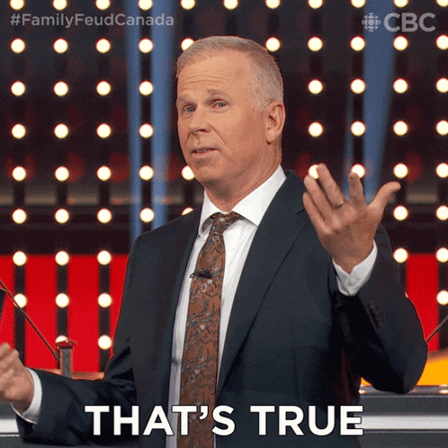 a man in a suit and tie says that 's true in front of a crowd