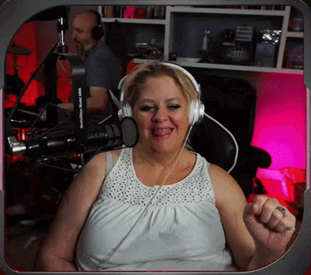 a woman wearing headphones is smiling in front of a microphone that says " brooklyn radio "