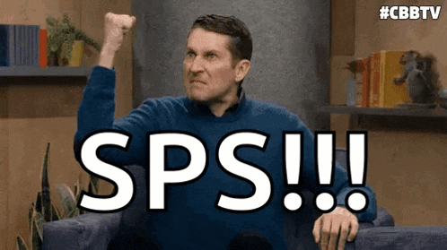 a man is sitting on a couch with his fist in the air and the word sps written on the screen