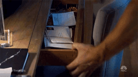 a person is reaching into a drawer with a nbc logo in the corner