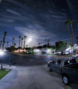 a truck is parked on the side of the road in a residential area at night