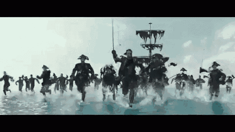 a large group of pirate soldiers are running through the ocean .