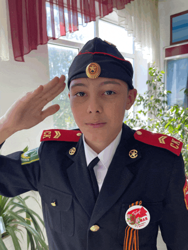 a young man in a military uniform salutes with a badge on his uniform that says " mar "