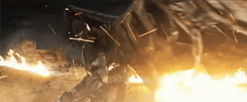 a robot is standing in the middle of a fire and explosion .