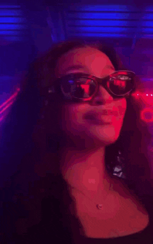 a woman wearing sunglasses in a dark room