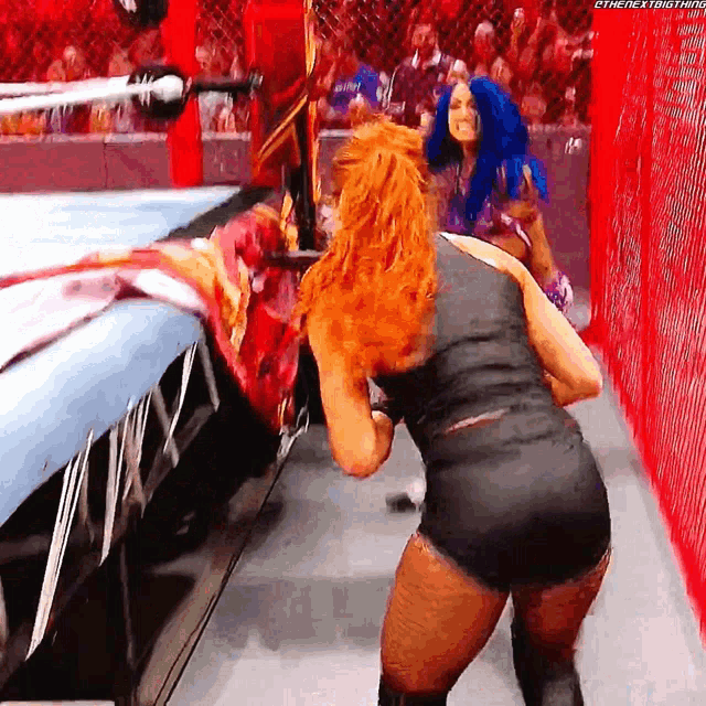 two women are wrestling in a ring and one of them is wearing blue